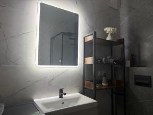 a bathroom with a white sink and a mirror at Mazury Mood kawalerka studio in Giżycko +18 photos