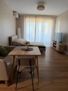 a living room with a couch and a table and a bed at Mazury Mood kawalerka studio in Giżycko