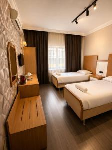 a hotel room with two beds and a television at OTEL MOLA BALIKESiR in Balıkesir