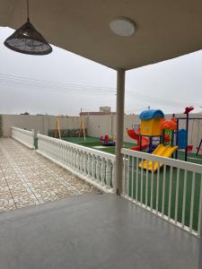 a playground with a play set on a fence at فيلا الريف in Kusāt