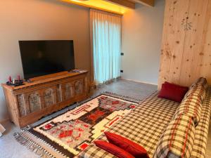 a bedroom with a television and a bed with a blanket at Il Fienile di Ebbe in Bormio