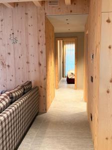a room with wooden walls and a couch and a bed at Il Fienile di Ebbe in Bormio