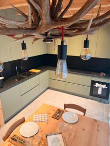 a kitchen with a wooden table with chairs and lights at Il Fienile di Ebbe in Bormio
