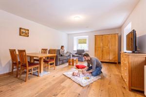a man playing with a baby in a living room at Vitalhof am Kreischberg by ALPS RESORTS in Bodendorf