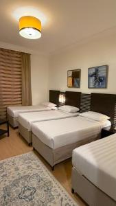 a bedroom with three beds in a room at Saif Al Majd Hotel in Mecca +23 photos