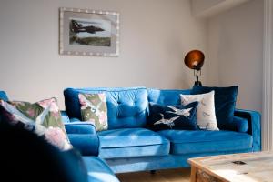 a blue couch in a living room with a table at Cymyran Terrace in Holyhead