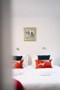 a bedroom with two beds with red pillows at Cymyran Terrace in Holyhead