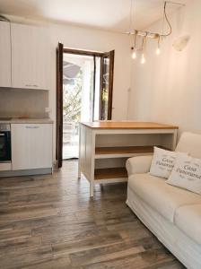 a living room with a couch and a kitchen at Casa Panorama Intelvi - Como & Lugano Lakes in Laino