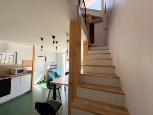 a staircase leading up to a kitchen with a table and chairs at L'échappée verte in Chirens