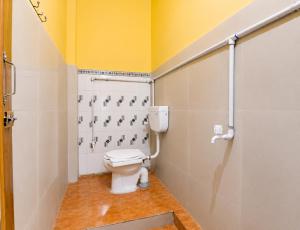 a bathroom with a toilet and a yellow wall at Hotel Alankar Lodge Kharagpur in Kharagpur +24 photos