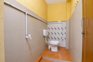 a bathroom with a toilet and a yellow wall at Hotel Alankar Lodge Kharagpur in Kharagpur