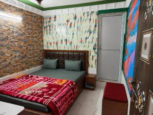 a bedroom with a bed in a room with a brick wall at Hotel Alankar Lodge Kharagpur in Kharagpur