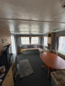 a living room with a couch and a table at 137 sealands, 3 bed, 8 berth caravan hire, ingoldmells, skegness recently modernised in Ingoldmells