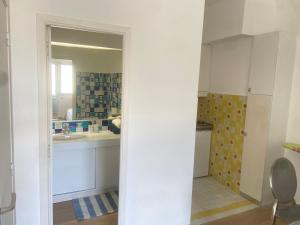 a white kitchen with a sink and a mirror at Studio avec piscine et grande terrasse Parking gratuit Nice in Nice