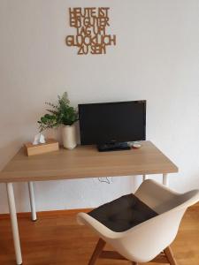 ein Schreibtisch mit Computermonitor und Stuhl in der Unterkunft Grüner Baum in Neckargerach