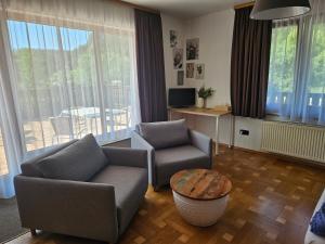 ein Wohnzimmer mit Sofa, Stühlen und einem Tisch in der Unterkunft Grüner Baum in Neckargerach