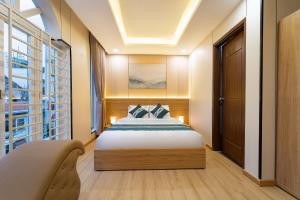 a bedroom with a bed and a large window at Green Airport Hotel 2 in Ho Chi Minh City