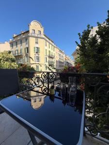 a blue table on a balcony with a building at Hôtel Parisien in Nice