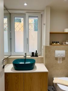 a bathroom with a blue sink on a counter at Corcyra Collection in Corfu