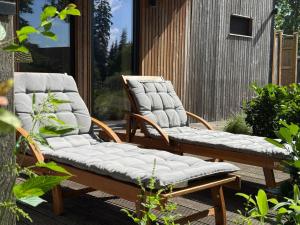 two wicker chairs sitting on a patio at Großzügiges Tiny House in Sumte