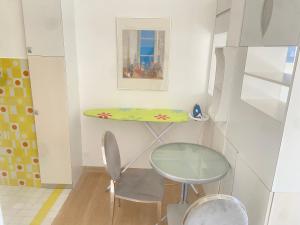 a small table and a chair in a room at Studio avec piscine et grande terrasse Parking gratuit Nice in Nice