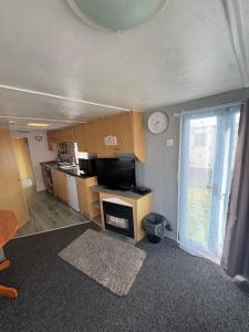 a living room with a kitchen and a window at 137 sealands, 3 bed, 8 berth caravan hire, ingoldmells, skegness recently modernised in Ingoldmells