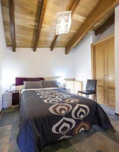 - une chambre avec un grand lit et une chaise dans l'établissement El Abrigaño del Cañón, à Pesquera de Ebro