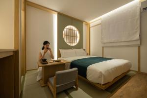 a woman talking on a phone in a hotel room at Anook Ryokan Hotel Suwon Ingye in Suwon +112 photos