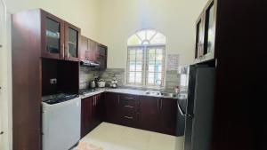 a kitchen with wooden cabinets and a sink and a window at Eco Villa Resort in Negombo +20 photos