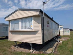 a tiny house sitting on display in a yard at Seashell Cove - 2 bedrooms sleeps 6 in Dymchurch +8 photos