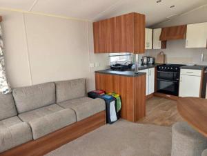 a living room with a couch and a kitchen at Seashell Cove - 2 bedrooms sleeps 6 in Dymchurch