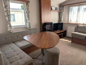 a living room with a couch and a table at Seashell Cove - 2 bedrooms sleeps 6 in Dymchurch