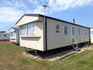 a tiny house is parked in a yard at Seashell Cove - 2 bedrooms sleeps 6 in Dymchurch