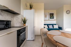 a kitchen and living room with a table and a couch at Rumia Stylish Apartment by BookingHost in Rumia