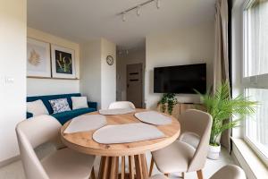a living room with a wooden table and chairs at Rumia Stylish Apartment by BookingHost in Rumia