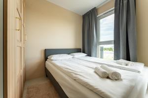 a bedroom with a bed with towels on it at Rumia Stylish Apartment by BookingHost in Rumia