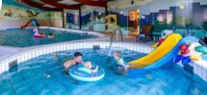 a man and a child playing in a swimming pool at Chalet Masion Meerwijck 6 aan het Zuidlaardermeer in Kropswolde