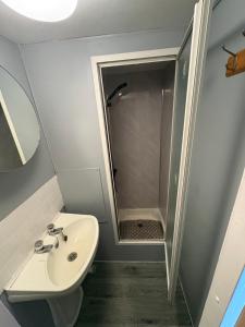 a small bathroom with a sink and a shower at 137 sealands, 3 bed, 8 berth caravan hire, ingoldmells, skegness recently modernised in Ingoldmells +11 photos