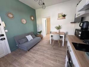 a living room with a couch and a table at Le Paisible - proche des Thermes in Chamalières +16 photos