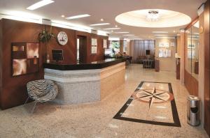 a lobby with a reception desk in a building at Lira Hotel in Curitiba