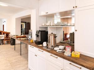 a kitchen with white cabinets and a wooden counter top at Pensjonat Lider in Szklarska Poręba