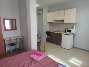 a room with a kitchen and a table with a bed at Miranis in Byala +29 photos