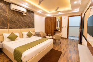a hotel room with a bed and a tv at Mazestic Bay Hotel & Banquet in Noida