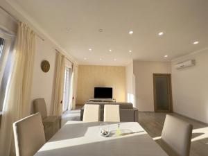 a living room with a table and chairs and a television at Blu costiera Casa Vacanze in Maiori