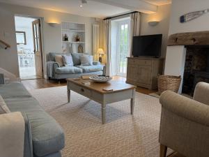 a living room with a couch and a tv at Fisherbridge Cottage in Weymouth