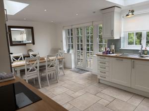 a kitchen and dining room with a table and chairs at Fisherbridge Cottage in Weymouth