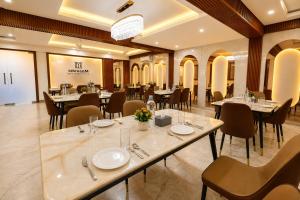 a restaurant with tables and chairs in a room at Mazestic Bay Hotel & Banquet in Noida