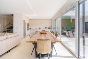 a kitchen and dining room with a wooden table and chairs at Paradise Villa Sea - Signature by Paradise Portugal in Ribamar