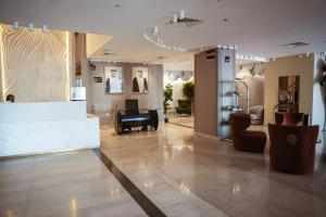 a lobby with a waiting room with a piano at Al Mansour Plaza Hotel in Doha