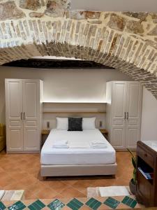 a bedroom with a white bed and a stone ceiling at Corcyra Collection in Corfu